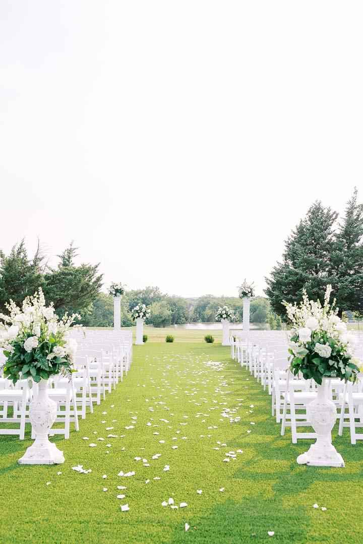A white wedding ceremony set up in The Garden at The Cinnamon Barn.